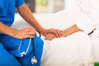 Nurse holds hand of patient